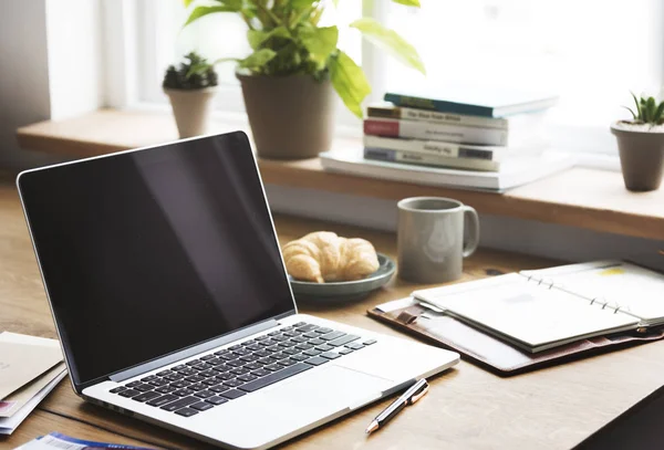 Opened laptop on table with food — Stock Photo, Image