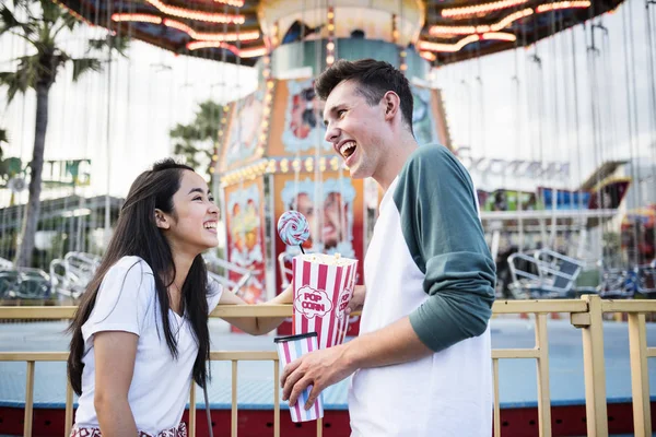 Casal rindo no parque de diversões — Fotografia de Stock