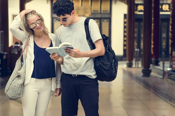 Pareja buscando en la guía — Foto de Stock