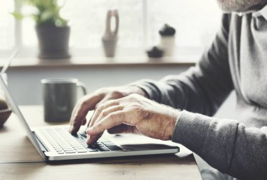 Kıdemli dijital dizüstü bilgisayar kullanan adam