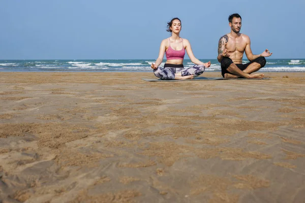 Coppia che fa yoga sulla spiaggia — Foto Stock