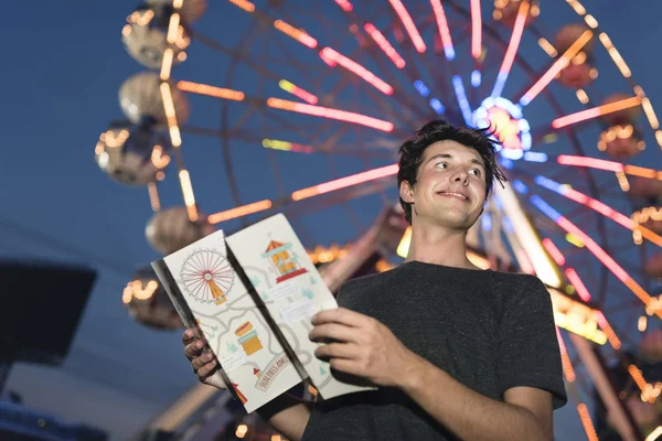Молодий чоловік з картою в парку розваг — стокове фото