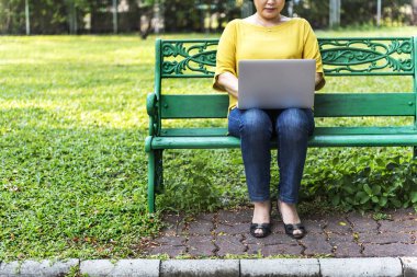 parkta dizüstü kullanan kadın