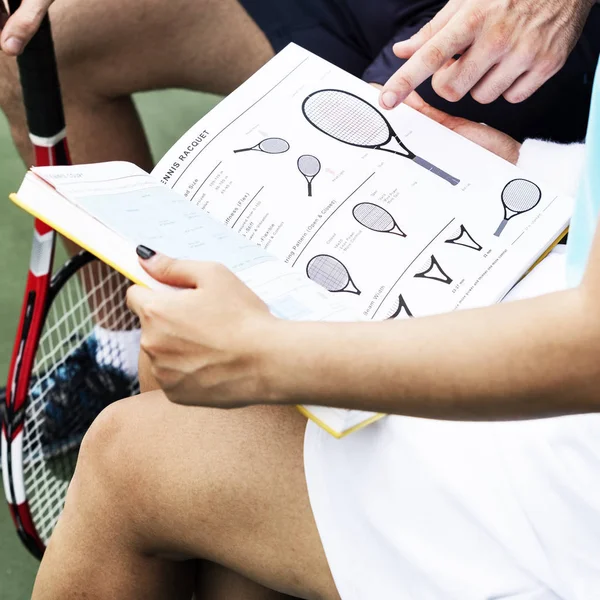 Fille et formateur lecture livre de tennis — Photo