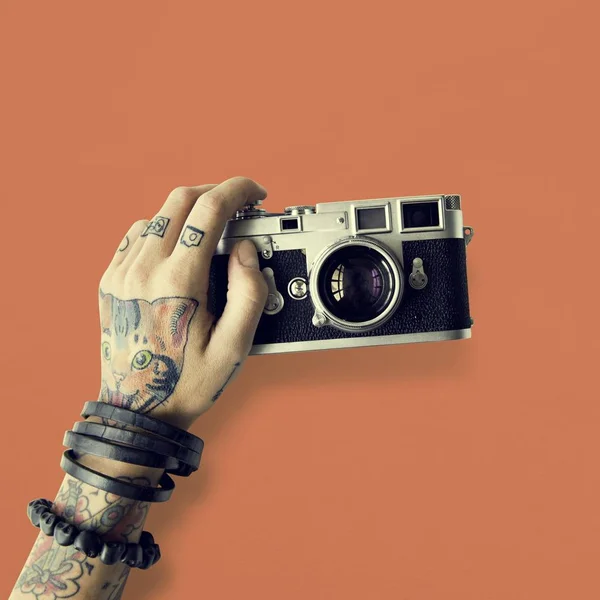 Mão em tatuagens detém câmera fotográfica — Fotografia de Stock