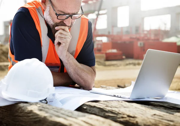 Obrero de la construcción con plan de arquitectura — Foto de Stock