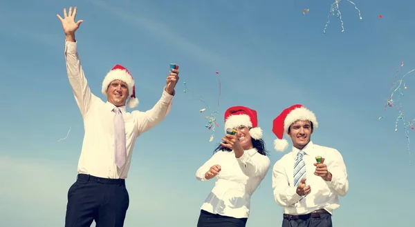 Affärskollegor i Santa hattar på stranden — Stockfoto