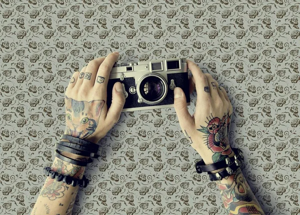 Manos en tatuajes sostiene cámara fotográfica —  Fotos de Stock