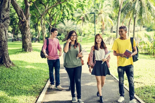 Diversos estudantes caminhando no parque — Fotografia de Stock