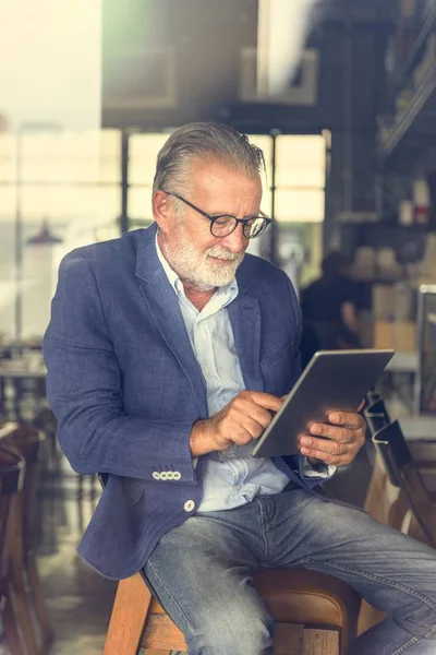 Uomo anziano utilizzando tablet digitale — Foto Stock