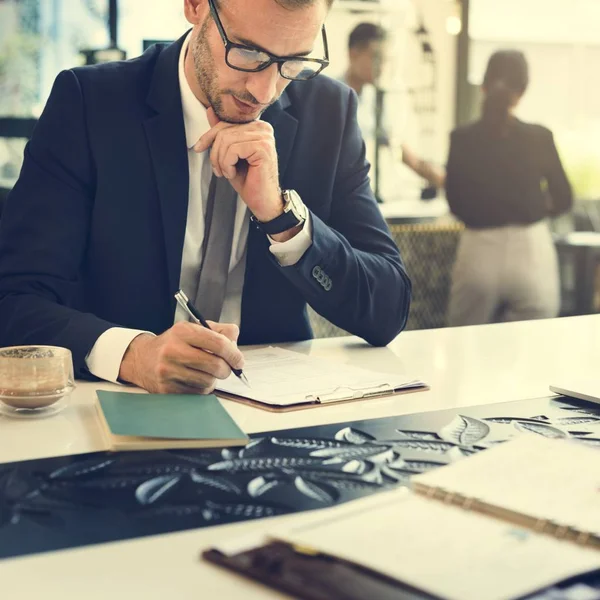 Geschäftsmann schreibt in Notizbuch — Stockfoto