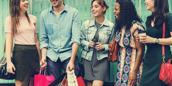 Amigos alegres segurando sacos de compras — Fotografia de Stock