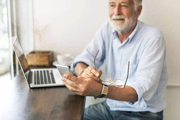 Senior man doorbladeren mobiele telefoon — Stockfoto