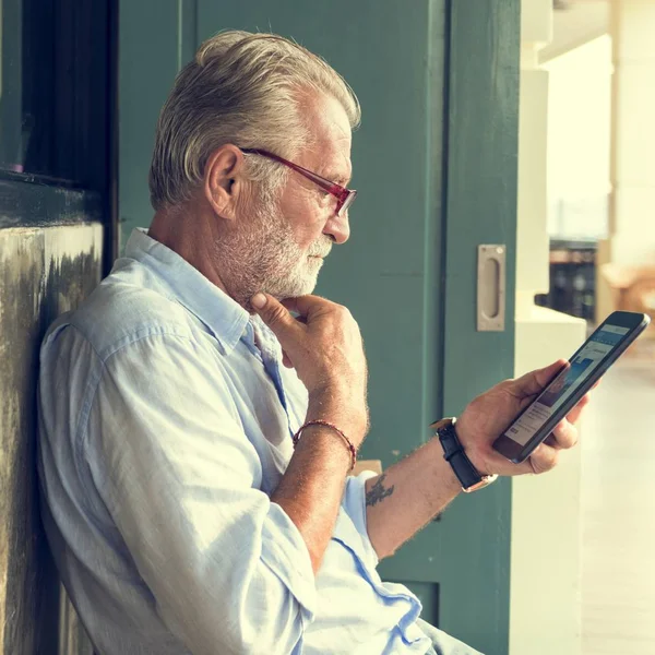 Senior man die digitale tablet gebruikt — Stockfoto