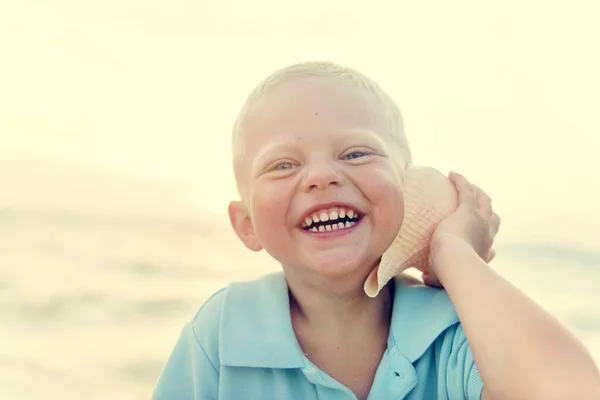 Piccolo ragazzo ascolto shell — Foto Stock