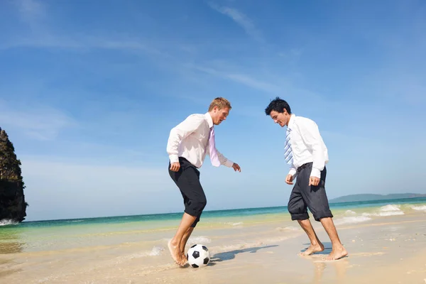 Colegas de negocios jugando al fútbol en la playa — Foto de Stock