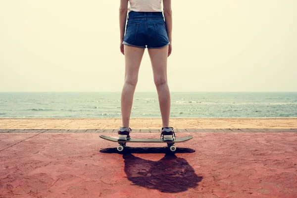 Chica en pantalones cortos montando en monopatín — Foto de Stock