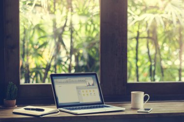 Beyaz Kupası ile pencere üstünde laptop