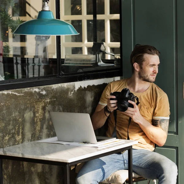 Mann mit Kamera sitzt in Straßencafé — Stockfoto