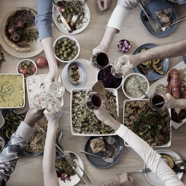 Pessoas sentadas à mesa com comida — Fotografia de Stock