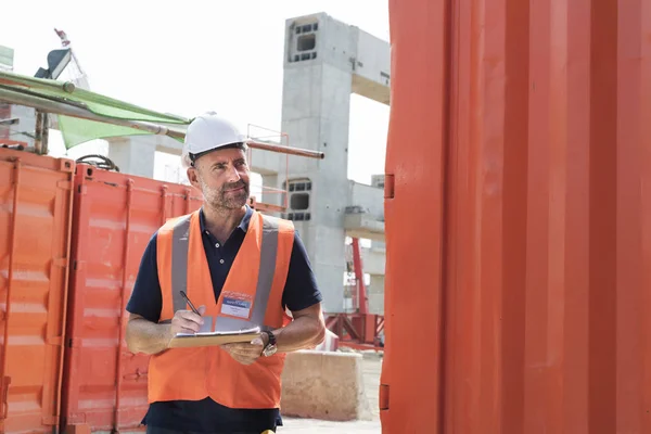 Trabalhador da construção civil com plano de arquitetura — Fotografia de Stock