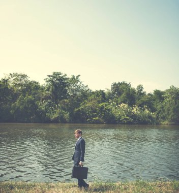 Nehir kıyısında ayakta işadamı