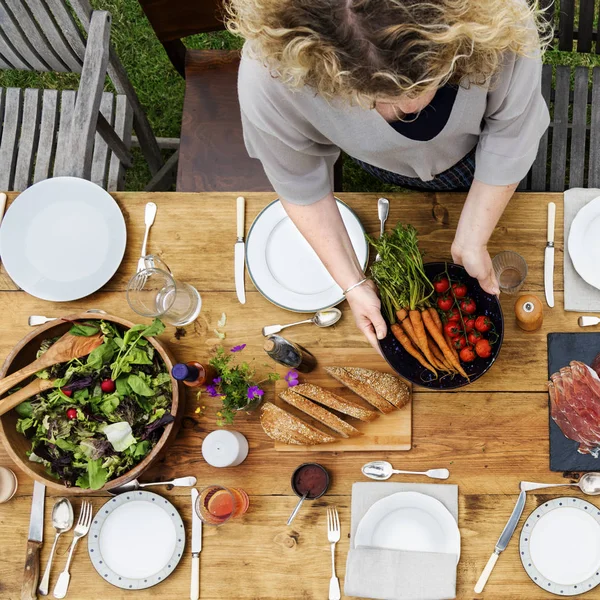 Huisvrouw voorbereiden tafel voor het diner — Stockfoto