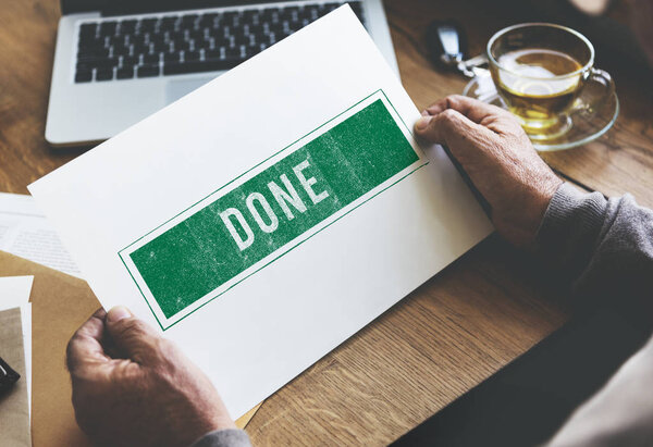 person holding paper at wooden table