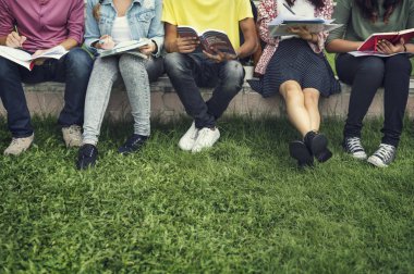 Diverse students sit at park clipart