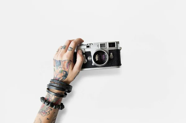 Рука об руку татуировки держит фотоаппарат — стоковое фото