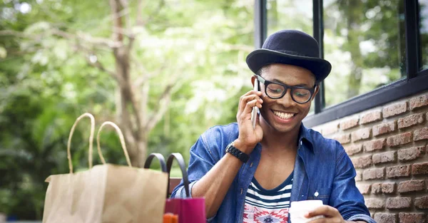 Man with shopping bag using smartphone — Stock Photo, Image