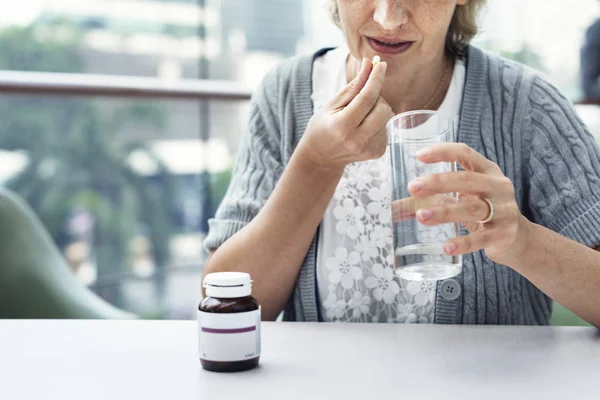 Mujer tomando pastillas — Foto de Stock