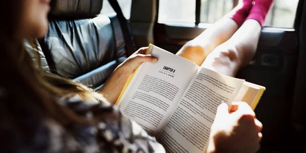 Mädchen liest Buch im Auto — Stockfoto