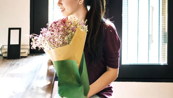若い女性の笑顔と花を持って — ストック写真