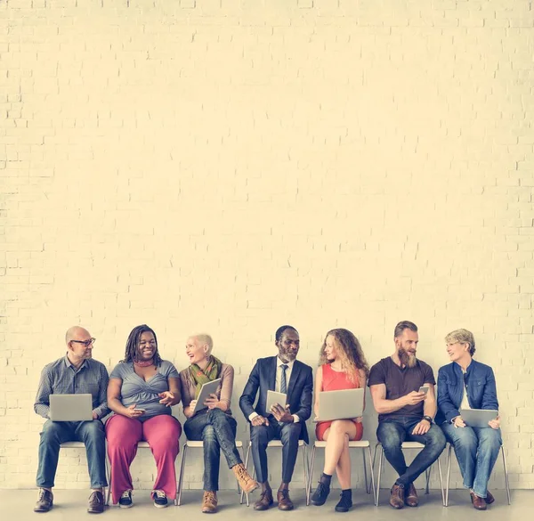 Menschen sitzen auf Stühlen — Stockfoto