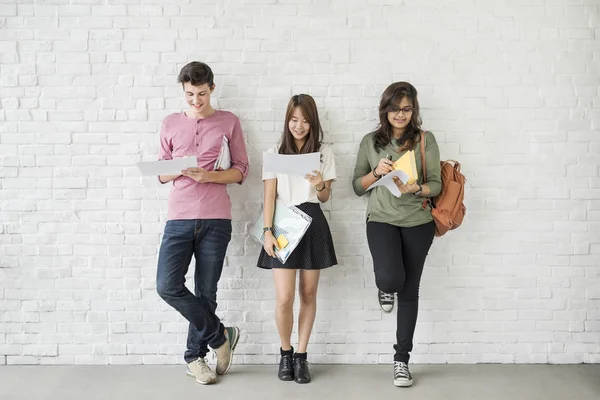 Students standing against white wall — Stock Photo, Image