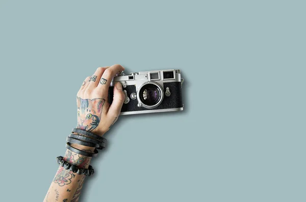 Mano en tatuajes sostiene foto cámara — Foto de Stock