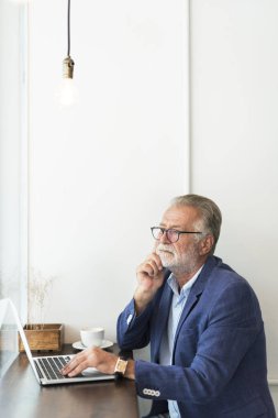 Dizüstü bilgisayar kullanan kıdemli adam.