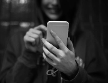 Akıllı telefon kullanan genç bir kadın.