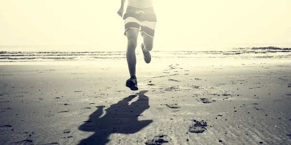 Sportlicher Mann läuft am Strand — Stockfoto