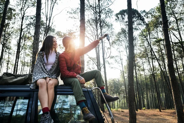 Casal sentado no carro na floresta — Fotografia de Stock