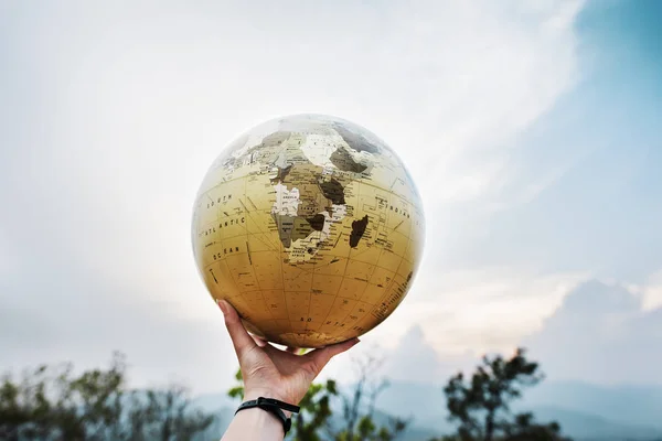 Mão segurando globo — Fotografia de Stock