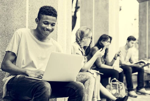 Unge mangfoldige venner studerer utendørs – stockfoto