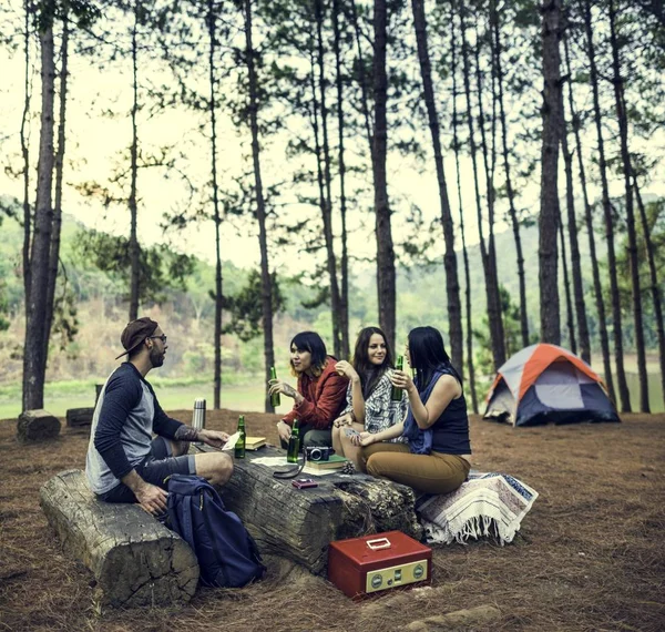 Amigos que têm bebidas no acampamento — Fotografia de Stock