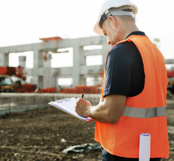 Obrero de la construcción con plan de arquitectura —  Fotos de Stock