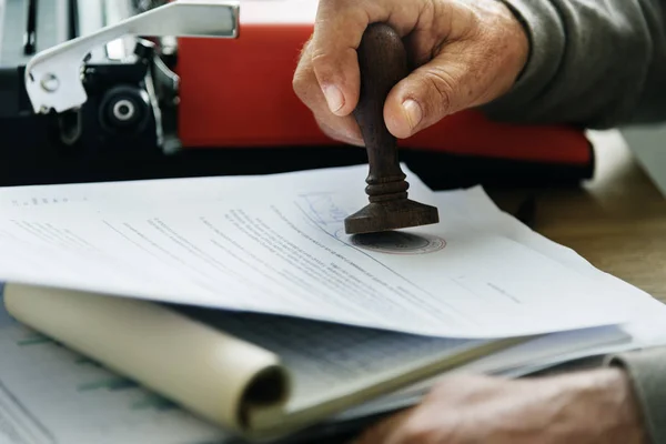 man putting stamp in diary