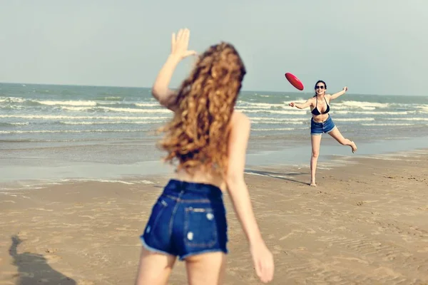 Chicas jugando frisbee en la playa —  Fotos de Stock