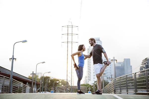 Sportliches Paar streckt sich auf der Straße — Stockfoto