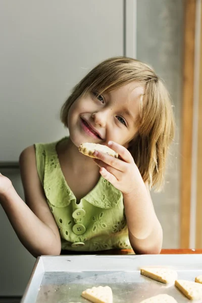 Meisje eten zelfgemaakte koekjes — Stockfoto