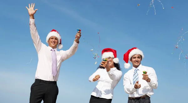 Geschäftskollegen mit Weihnachtsmützen am Strand — Stockfoto